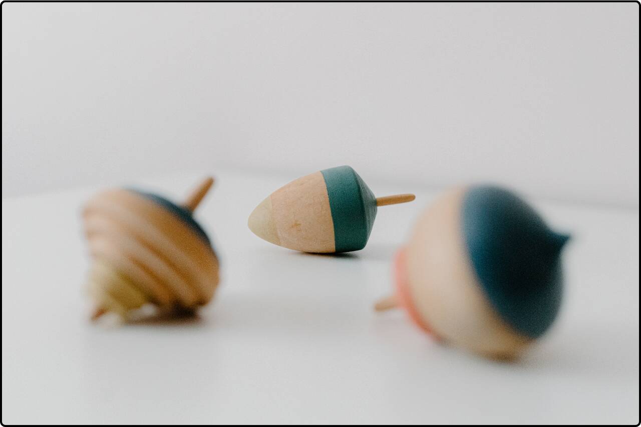 Close-up of handcrafted wooden spinning tops with vibrant designs.